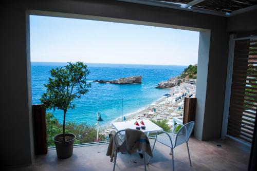 a view of the ocean from a balcony with a table and chairs at Folie Marine Hotel & Beach Club in Jal