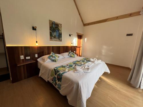 a hotel room with a bed with towels on it at Mercedes Lodge in San Ramón
