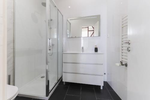 La salle de bains blanche est pourvue d'un lavabo et d'une douche. dans l'établissement Bright Santa Catarina by Homing, à Lisbonne
