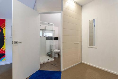 a bathroom with a toilet and a glass door at Gawler Townhouses 1a in Gawler