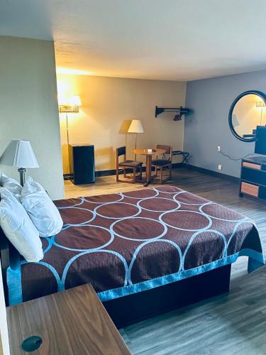 a hotel room with a bed and a table at Super 8 by Wyndham Corbin KY in Corbin