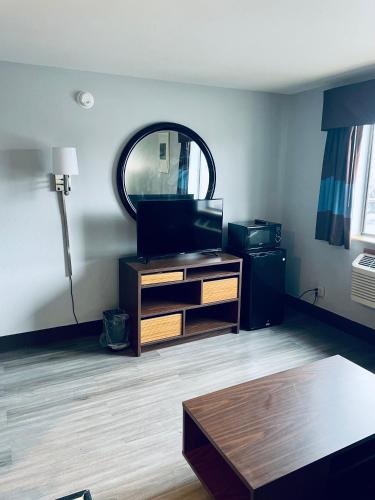 a living room with a tv and a mirror at Super 8 by Wyndham Corbin KY in Corbin