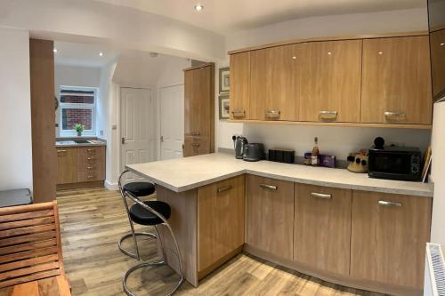 a kitchen with wooden cabinets and a counter top at Renovated home, fab location, garden, pet friendly and parking in Chester