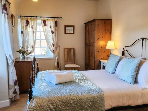 a bedroom with a large bed with blue pillows at Quay Cottage in Cramond