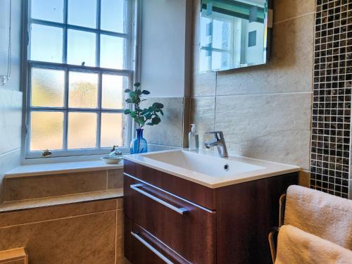 a bathroom with a sink and a window and a tub at Quay Cottage in Cramond