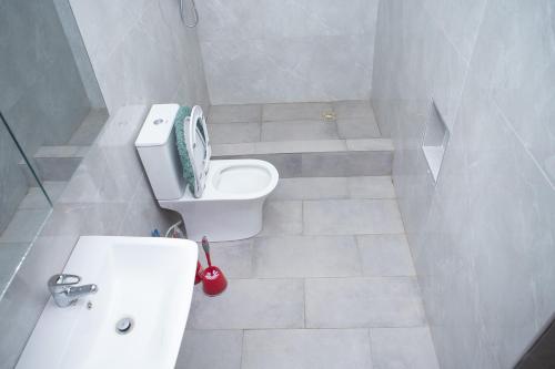 a bathroom with a toilet with a scale on the back of it at Urban Condos in Accra