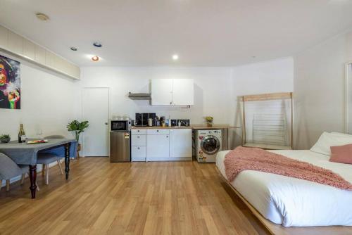a bedroom with a bed and a table and a kitchen at Gawler Townhouses 1b in Gawler