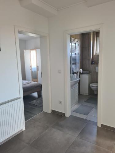 a white bathroom with a toilet and a sink at Apartman Lea in Kraljevec Sesvetski