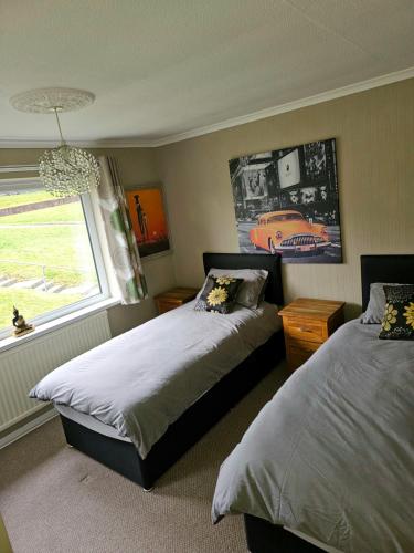 een slaapkamer met 2 bedden en een raam bij 3 Bedroom family home Newport, Located next to M4 in Newport