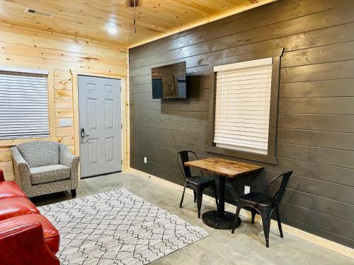 a living room with a table and chairs and a couch at Knotty Squirrel Cabins in Mountain View