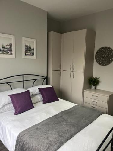 a bedroom with a large bed with purple pillows at Stanley Street Apartment in Southport