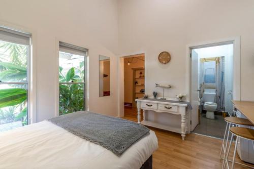 een slaapkamer met een bed en een badkamer met een wastafel bij Gawler Townhouses 1 Bedroom (1c) in Gawler
