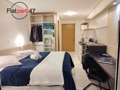 南卡希亞斯的住宿－Flatzer047 Executivo，一间卧室配有一张床和一张带笔记本电脑的书桌