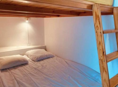 een slaapkamer met een stapelbed met 2 kussens bij Studio vue mer avec piscine in Saint-Jean-de-Monts