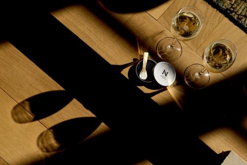 a table with two glasses of wine on it at La Chapelle, Les Suites du Palais, l'unique 5 étoiles de Nevers, Suite d'Exception, by PRIMO C0NCIERGERIE in Nevers