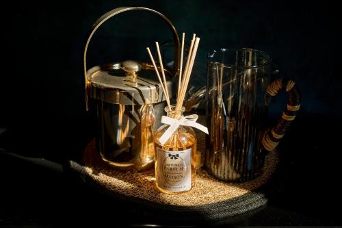 a table with two bottles and a container with sticks at La Chapelle, Les Suites du Palais, l'unique 5 étoiles de Nevers, Suite d'Exception, by PRIMO C0NCIERGERIE in Nevers