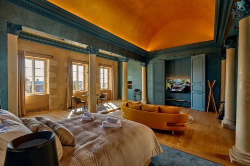 a living room with a bed and a couch at La Chapelle, Les Suites du Palais, l'unique 5 étoiles de Nevers, Suite d'Exception, by PRIMO C0NCIERGERIE in Nevers