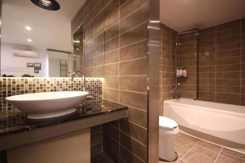 a bathroom with a sink and a toilet and a tub at Paradise Hotel in Gunsan-si