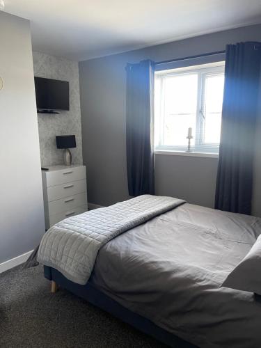 a bedroom with a bed and a window at Kevara Self-Catering in Finstown