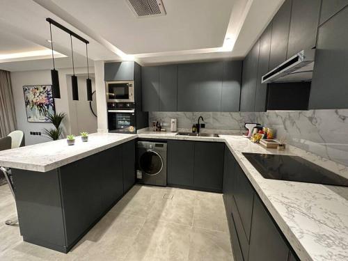 a kitchen with black cabinets and a washer and dryer at ROSE RESIDENCE I Luxury 3BR Apartment I North Riyadh in Riyadh