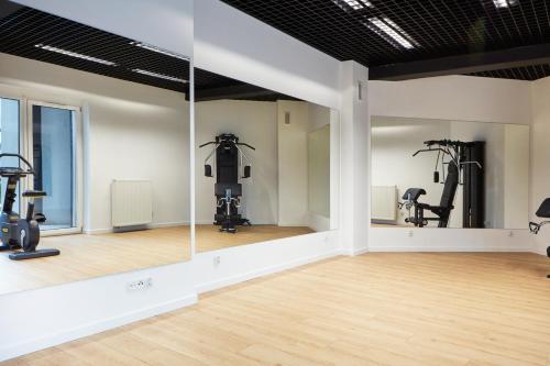 um ginásio com passadeiras e equipamento de exercício numa sala em Laguna Resort Beskidy & Wellness em Zarzecze
