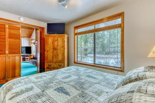 a bedroom with a bed and a large window at The Huckleberry Cabin in Sunriver