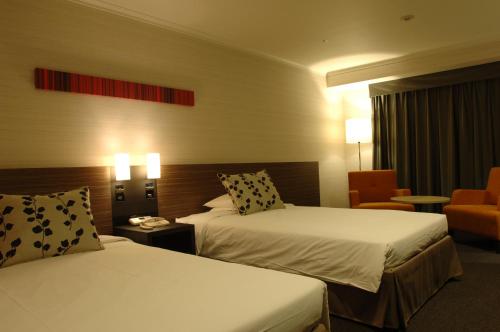 a hotel room with two beds and a chair at Nagoya Tokyu Hotel in Nagoya