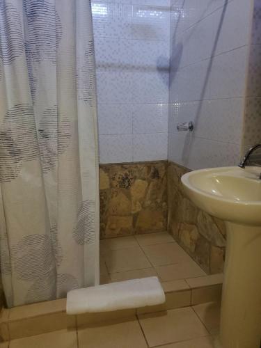 a bathroom with a shower curtain and a sink at Sunset Bay B&B in Corn Island