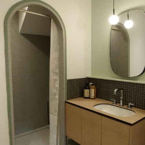 une salle de bain avec un lavabo et une douche avec un miroir dans l'établissement Maison à louer pour les vacances Les Pergolas, à Marcigny