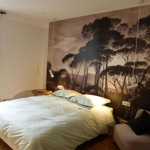 une chambre avec un grand lit avec un tableau au mur dans l'établissement Maison à louer pour les vacances Les Pergolas, à Marcigny