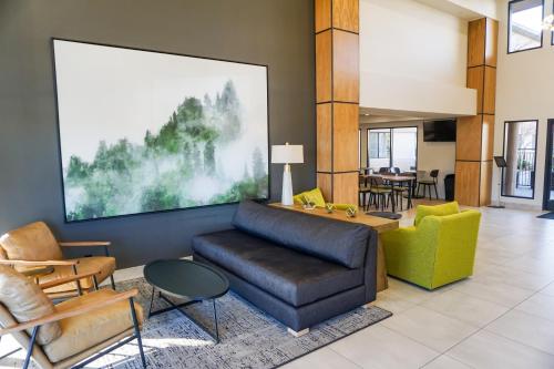 a living room with a couch and chairs and a table at Oxford Suites Redding in Redding