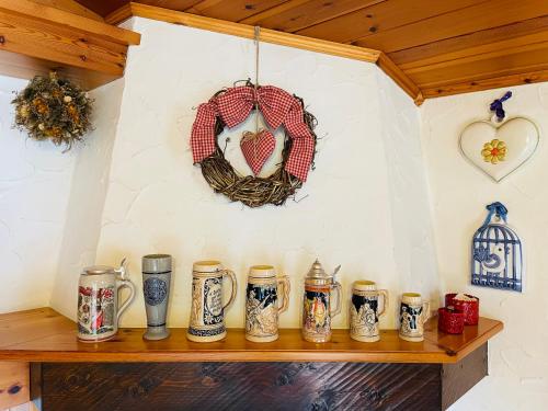 a shelf with vases and a wreath on a wall at Accogliente attico vista Dolomiti in Vodo Cadore