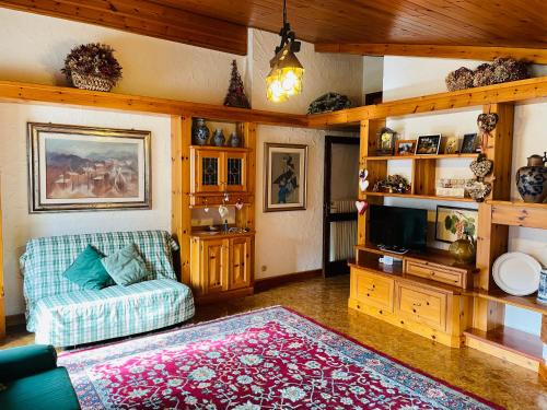 a living room with a couch and a tv at Accogliente attico vista Dolomiti in Vodo Cadore