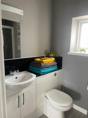 a white bathroom with a sink and a toilet at Kevara Self-Catering in Finstown