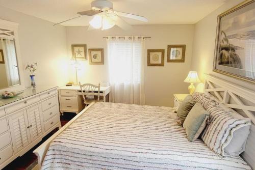 una camera con un grande letto e un ventilatore a soffitto di E10 comfortable and neat 2 bedroom 2 bath a Saint Simons Island