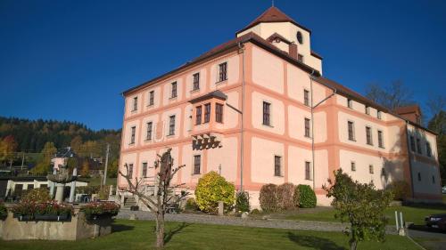 a large pink building with a clock tower on top at Hotel Garni Schloß Schönberg in Bad Brambach