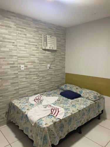 a bedroom with a bed with towels on it at Pousada João de Barro in Camaçari