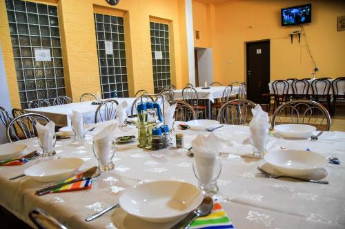 a table with white plates and napkins on it at PENSIUNEA HARTAGU in Baile Siriu