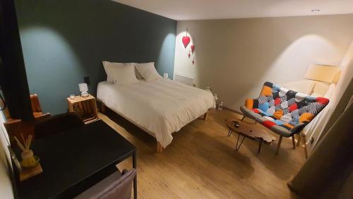 una camera con letto, divano e sedia di Votre chez vous a Bergheim