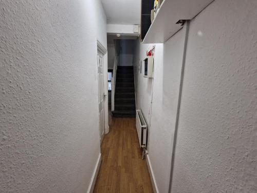 a hallway with white walls and a stair case at City Budget Guesthouse in London