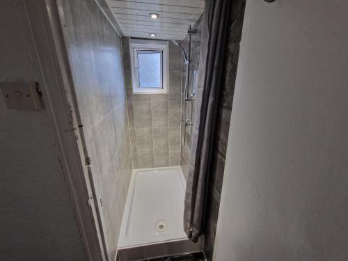 a small bathroom with a shower and a toilet at City Budget Guesthouse in London