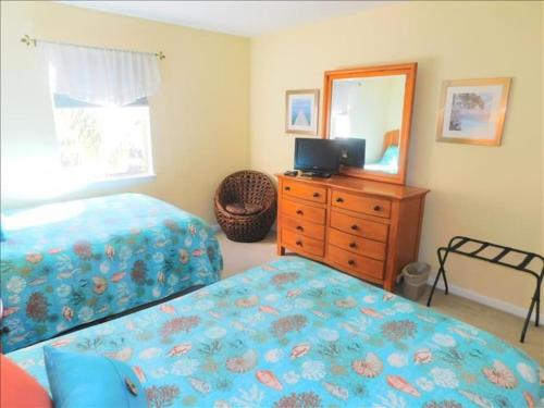 a bedroom with a bed and a dresser and a mirror at A12 1 bedroom with 2 beds and great view of pool, upstairs, new floors, two full size beds in Saint Simons Island