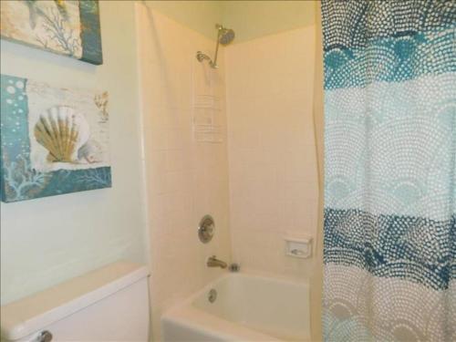 a bathroom with a shower and a sink and a toilet at A12 1 bedroom with 2 beds and great view of pool, upstairs, new floors, two full size beds in Saint Simons Island