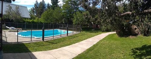 uma cerca em torno de uma piscina num quintal em Cabaña en Casa de Piedra em San Carlos de Bariloche