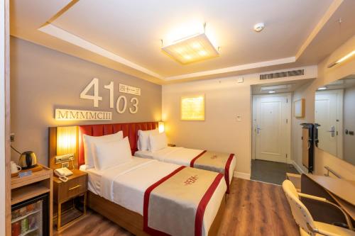a hotel room with two beds and a television at Ramada By Wyndham Istanbul Pera Taksim in Istanbul