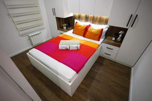 a bedroom with a large bed with colorful sheets at Apartman Morava in Čačak