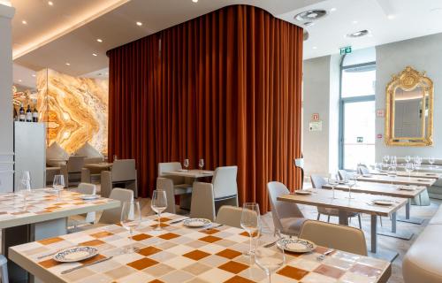 a restaurant with tables and chairs and a red curtain at Dos Reis by The Beautique Hotels in Lisbon