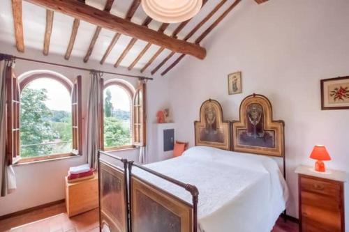 MarcianoにあるAgriturismo Podere Caggiolo - Swimming Pool & Air Conditioningのベッドルーム1室(ベッド1台、窓2つ付)