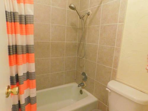 ein Bad mit einem Duschvorhang und einem WC in der Unterkunft A13 Pool view, easy access MGR American Dream in Mallory Park