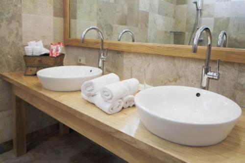 a bathroom with two sinks and towels on a counter at Sea Dream Resorts in Dauin